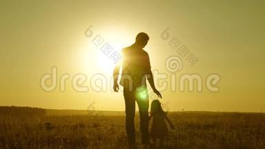 小女儿和<strong>爸爸</strong>牵着手在田野里走来走去。 孩子握着父亲的手。 <strong>爸爸</strong>和宝宝在公园里休息